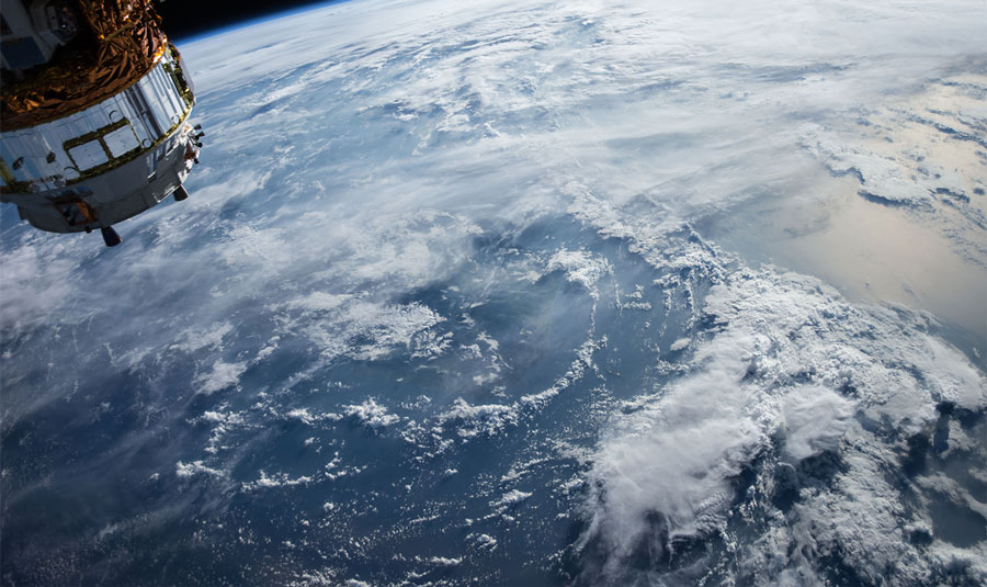 Satellite above Earth illustrating imagery and geomatics mapping